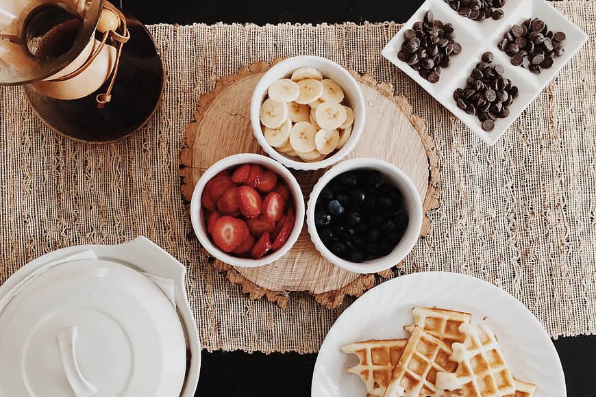 Overhead Flat Lay of Waffles, Fresh Berries, and Coffee on Rustic Table