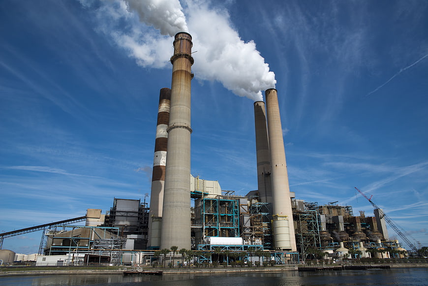 Industrial Power Plant Smoke Stacks Emitting Steam Against Blue Sky