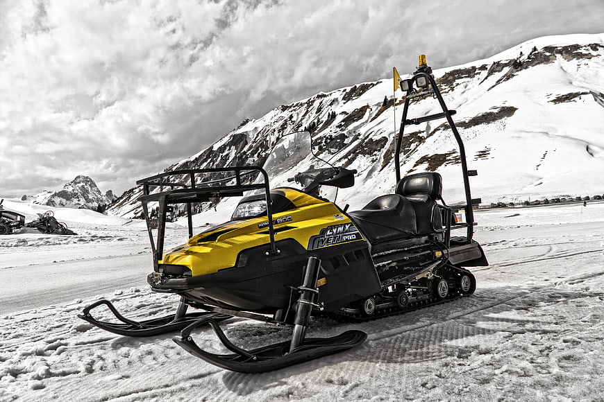 Yellow Snowmobile on Snowy Mountain Slope