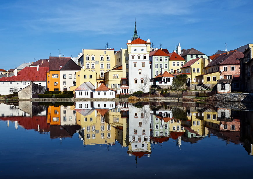 Colorful historic town buildings reflected in calm river water