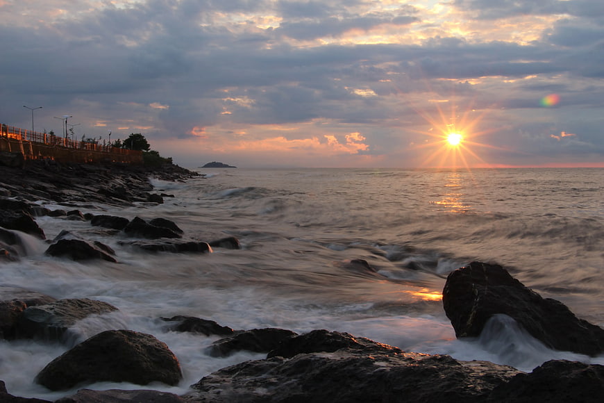 Dramatic Sunset Over Rocky Seashore with Long Exposure Waves