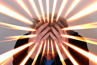 Senior man holding head with glowing light rays representing stress
