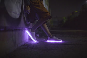 Person wearing purple LED light-up sneakers at night