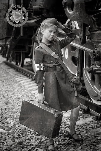 Young Girl in Military Uniform Holding Suitcase Near Train