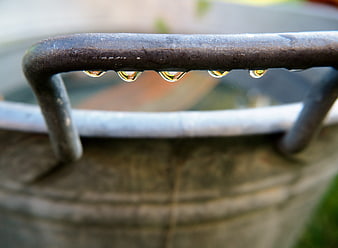 Close-up of water droplets on a rusty metal bucket handle