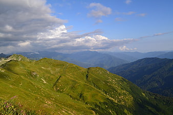 Panoramic View of Green Mountain Ridges Under Blue Sky