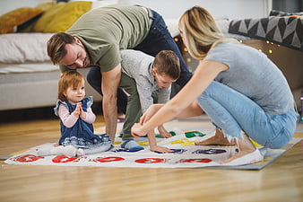 Happy family playing Twister game on living room floor