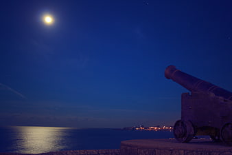 Old Cannon on Fort Wall at Night with Moon and Sea