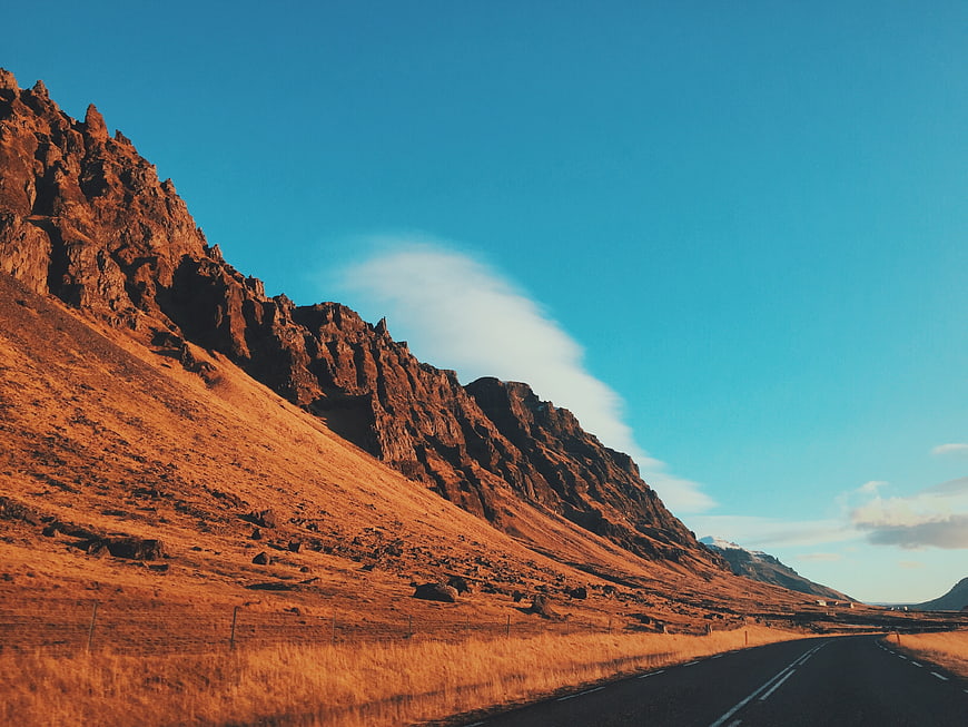 Scenic Mountain Road at Golden Hour with Blue Sky