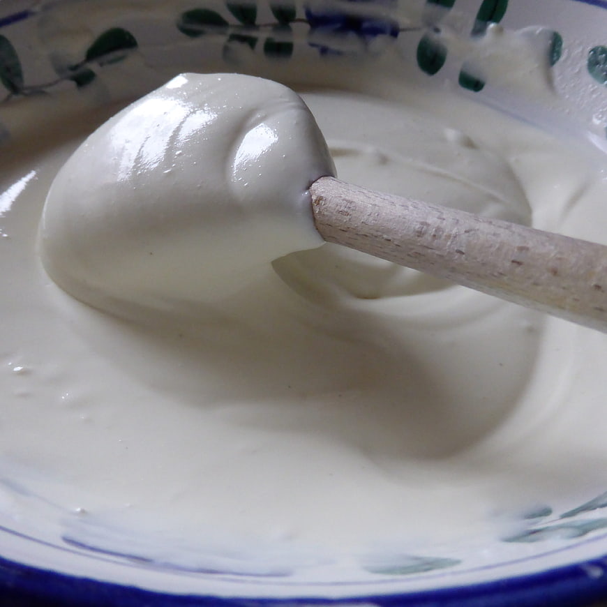 Close-up of creamy white quark cheese with wooden spoon