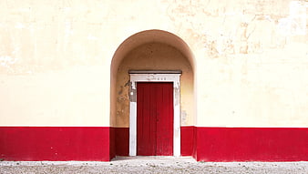 Red Wooden Door in Arched Yellow Wall