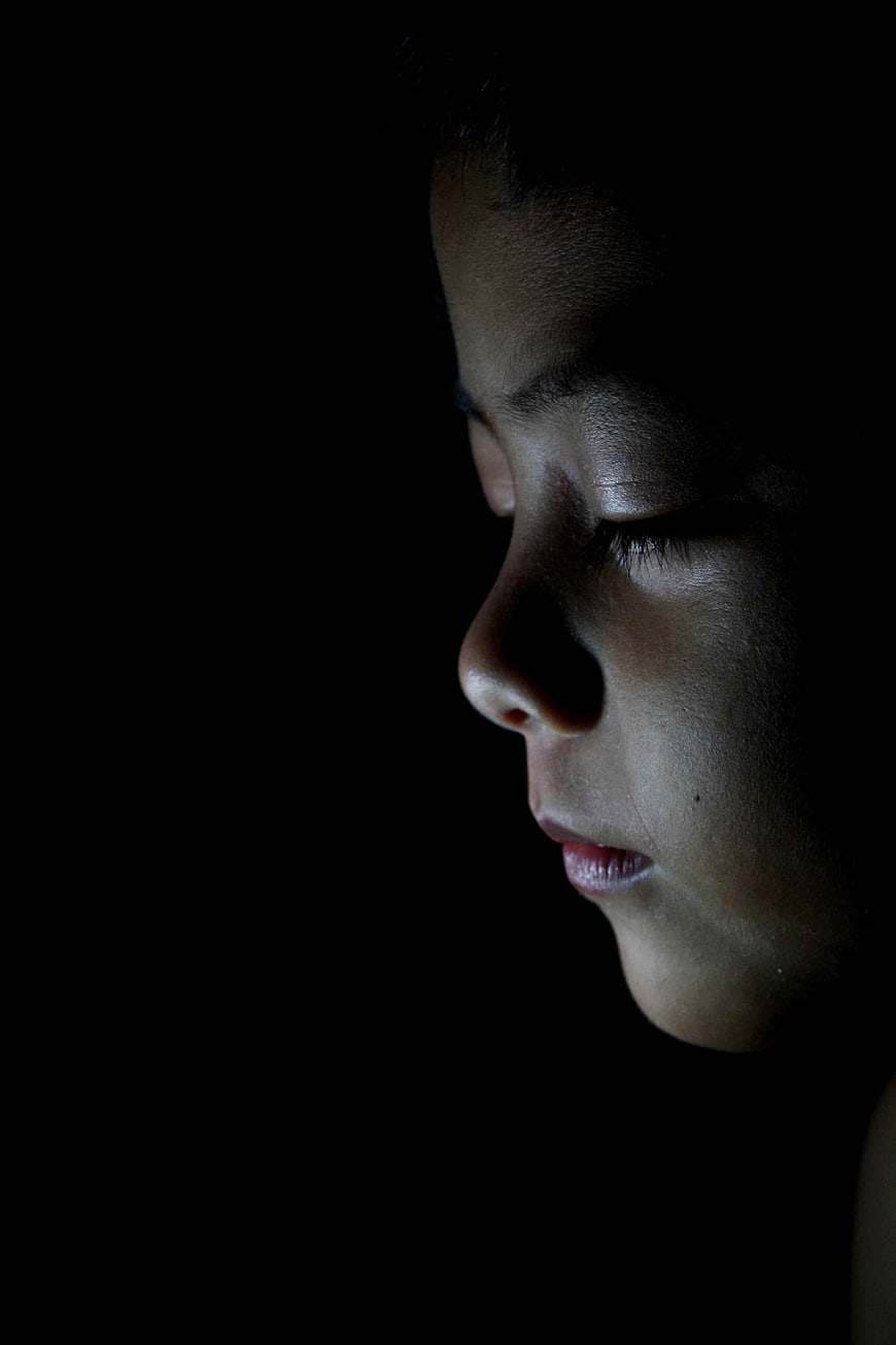 Close-up profile of a sleeping child's face in low light