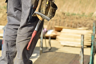 Construction worker with hammer and tool belt on site