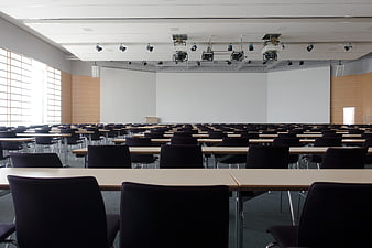 Empty modern lecture hall with rows of tables and chairs
