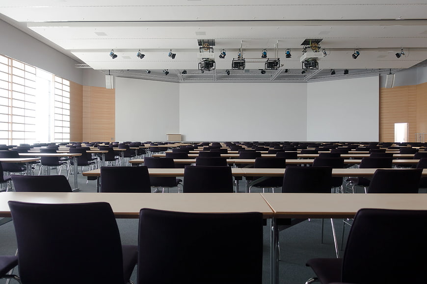 Empty modern lecture hall with rows of tables and chairs