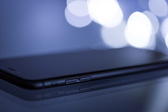 Close-up of Smartphone Side Buttons with Blue Bokeh Background