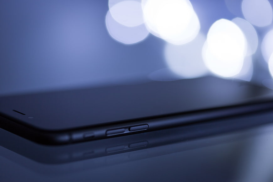 Close-up of Smartphone Side Buttons with Blue Bokeh Background
