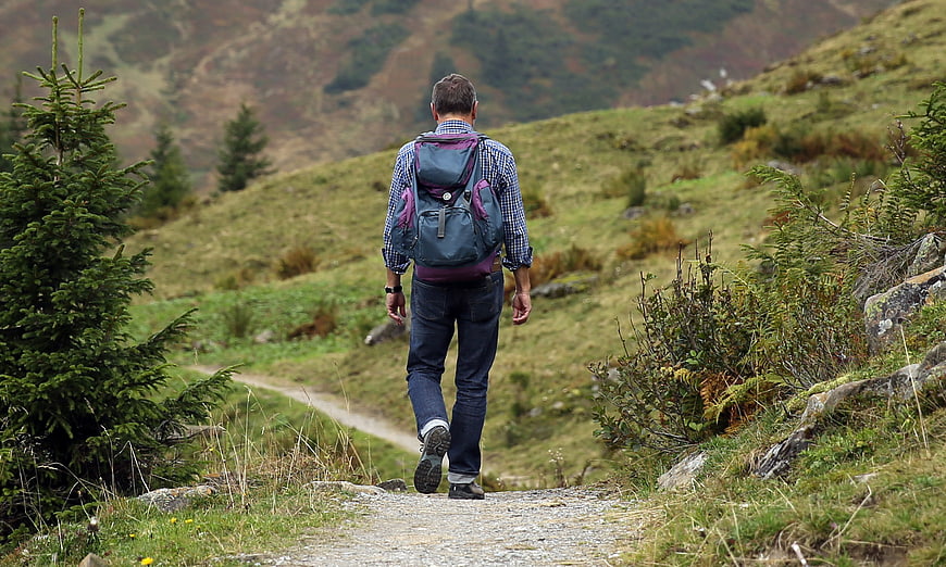Man hiking on mountain trail with backpack
