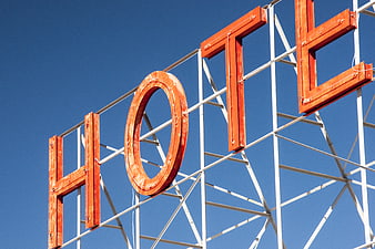 Vintage orange hotel sign against blue sky