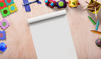 Top view of children's toys and art supplies on wooden background