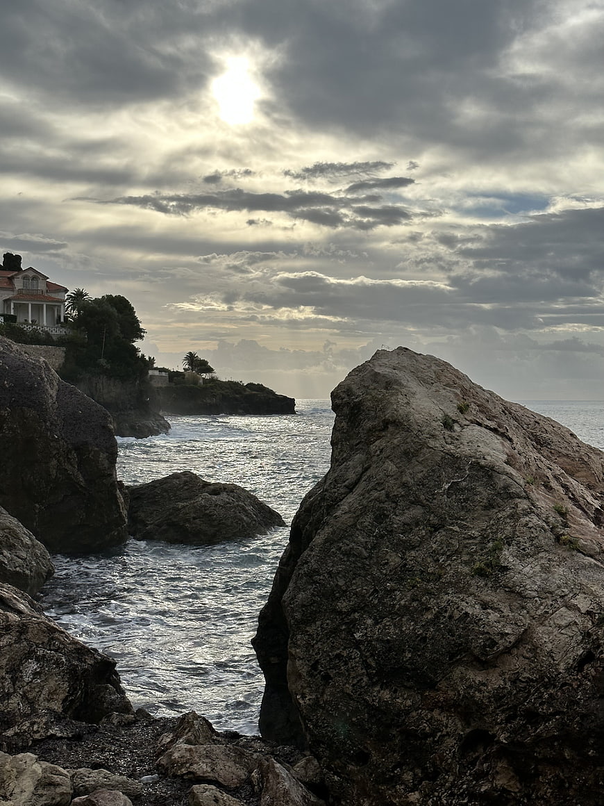 Dramatic Rocky Coastline with Cliffside Villa and Cloudy Sky