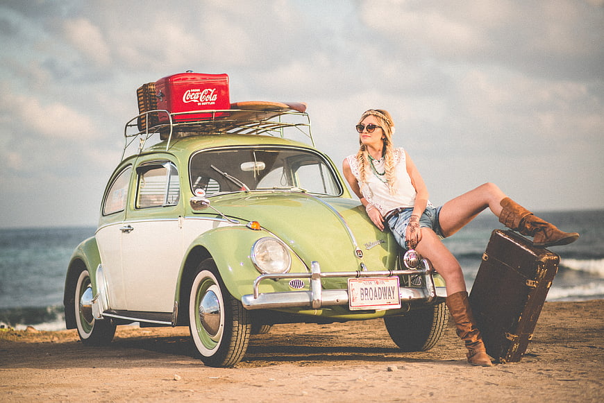 Stylish Woman Posing With Vintage Green Volkswagen Beetle On Beach