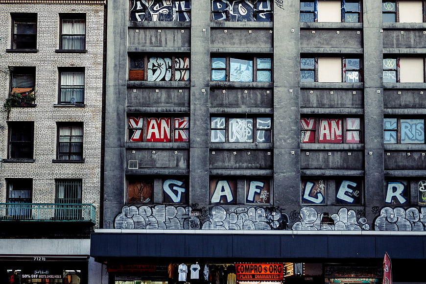 Urban graffiti art on concrete building facade with windows