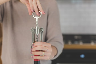 Woman Using Corkscrew to Open Wine Bottle