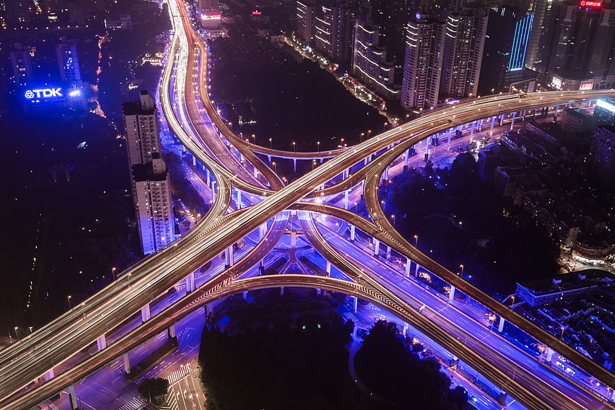 Aerial Night View of Complex City Highway Interchange with Light Trails
