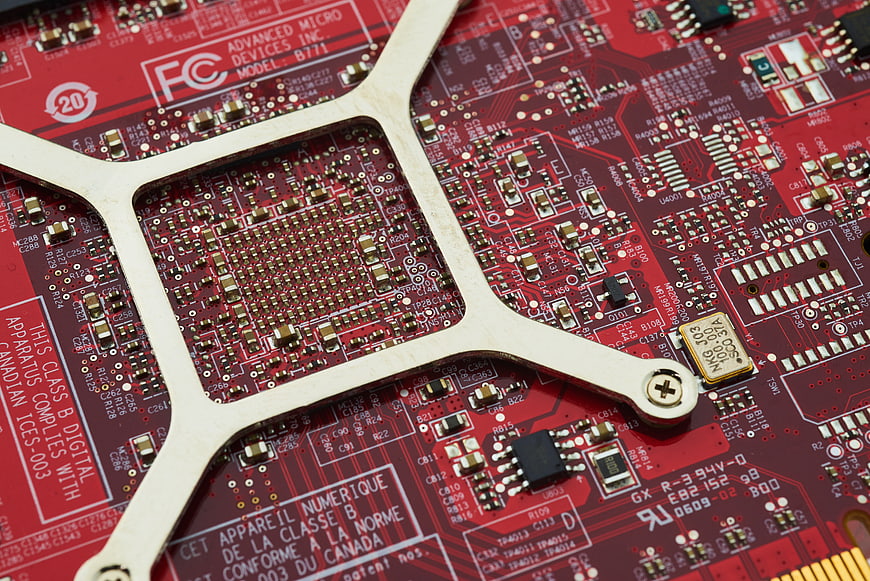 Close-up of red computer circuit board with metal bracket