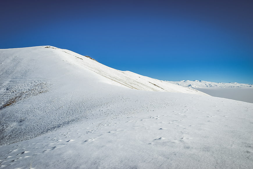 Snowy mountain ridge under clear blue sky