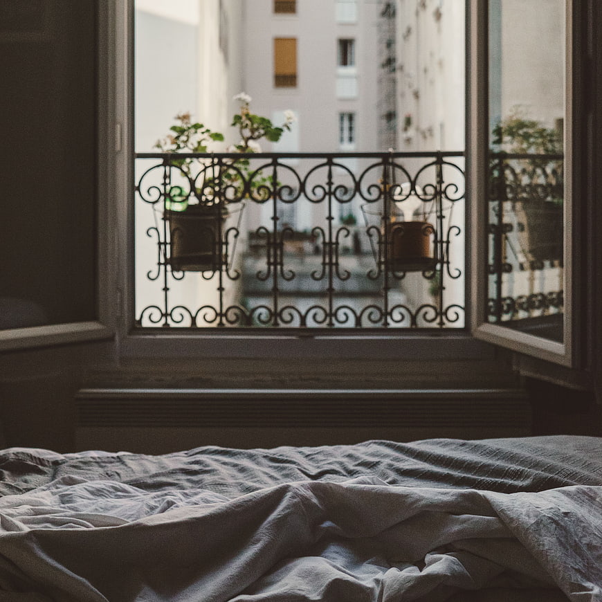 Cozy Bedroom Window View with Wrought Iron Balcony