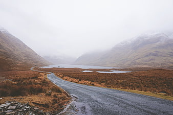 Winding Road Through Misty Highland Valley with Loch