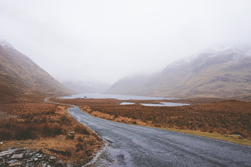 Winding Road Through Misty Highland Valley with Loch