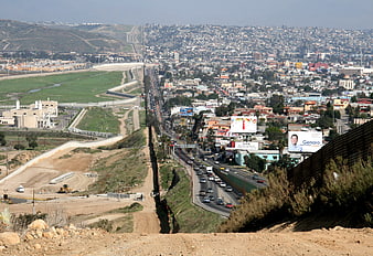 Aerial view of US-Mexico border wall and urban landscape