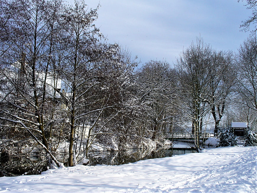 Snowy Winter Landscape with Frozen River and Bare Trees