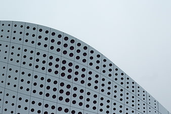 Modern curved building facade with perforated metal panels