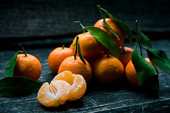 Fresh Mandarins with Leaves on Dark Wood
