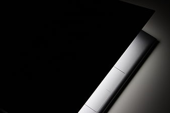 Close-up of sleek silver laptop edge on dark background