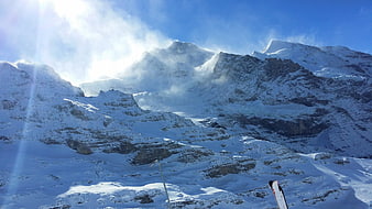 Snowboarder overlooking snowy Swiss Alps mountain range