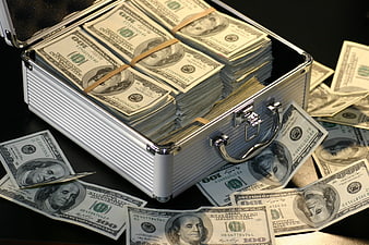 Open briefcase filled with stacks of hundred dollar bills