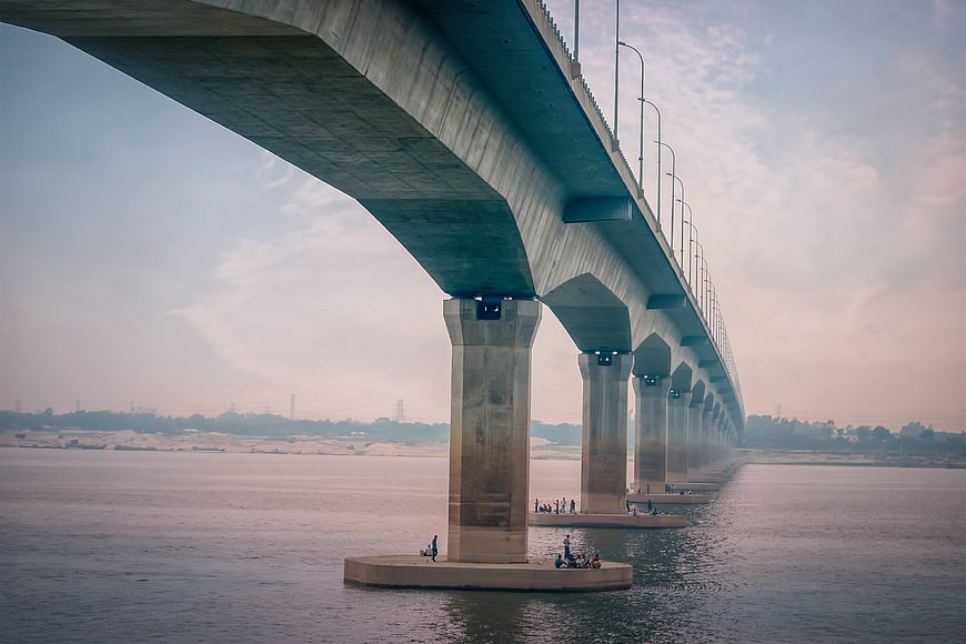 Low angle view of concrete bridge pillars over river
