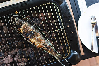 Top View of Grilled Fish in Wire Basket on Charcoal Grill