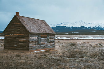 Weathered wooden cabin in snowy mountain landscape