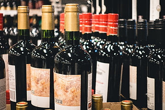 Rows of red wine bottles on store shelves