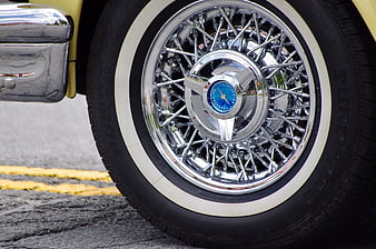Close-up of vintage car wire wheel with whitewall tire