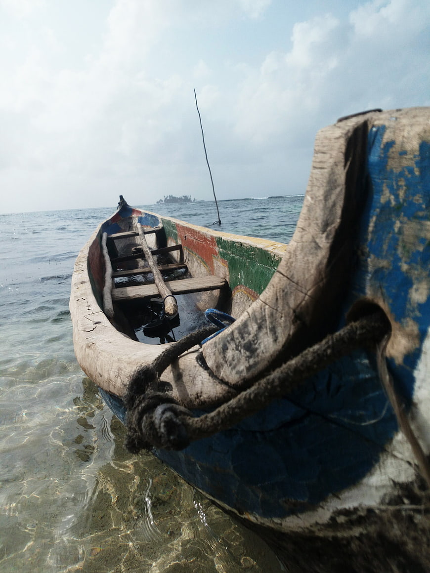 Weathered wooden fishing boat in clear tropical water
