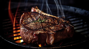 Sizzling Ribeye Steak Grilling on BBQ with Rosemary