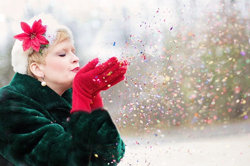 Woman in Christmas Hat Blowing Glitter Confetti