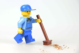 Lego construction worker minifigure sweeping with a broom